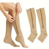 Pair of beige compression stockings with zippers shown on a leg and laid flat.