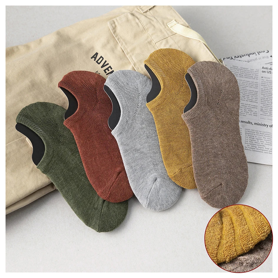 A collection of men's cotton crew socks in various earthy tones including olive green, brown, gray, and mustard yellow.