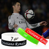 Grüne und rote Silikonarmband mit dem Namen und Logo von Cristiano Ronaldo neben einem weißen Armband.