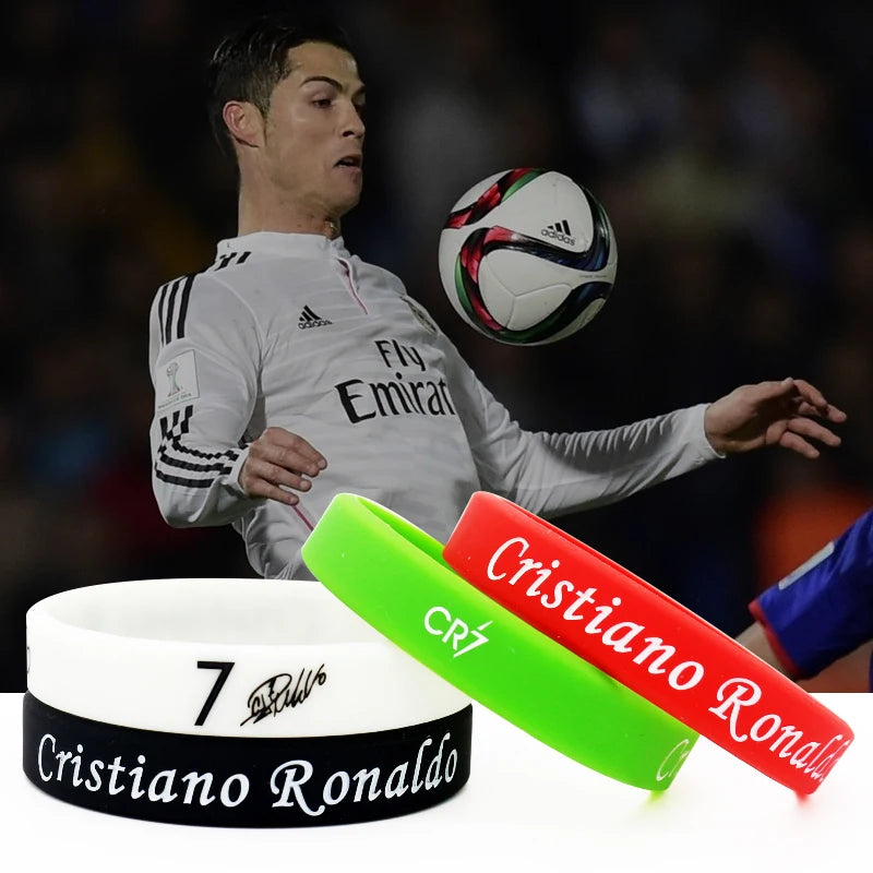 Grüne und rote Silikonarmband mit dem Namen und Logo von Cristiano Ronaldo neben einem weißen Armband.
