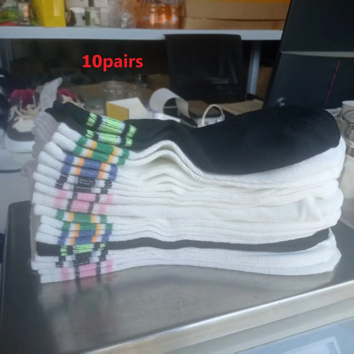Ten pairs of striped casual socks for men and women stacked on a shelf.