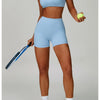 A woman models a light blue padded sport yoga bra and matching brief on a studio background.