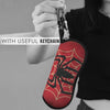 A hand holds a red spider web shaped keychain pouch with a black spider design.