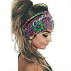 A woman wearing a floral butterfly patterned headband in purple and green on her forehead.