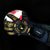 A close-up of black and gold high-performance goalkeeper gloves with white padding and a red accent on a dark background.