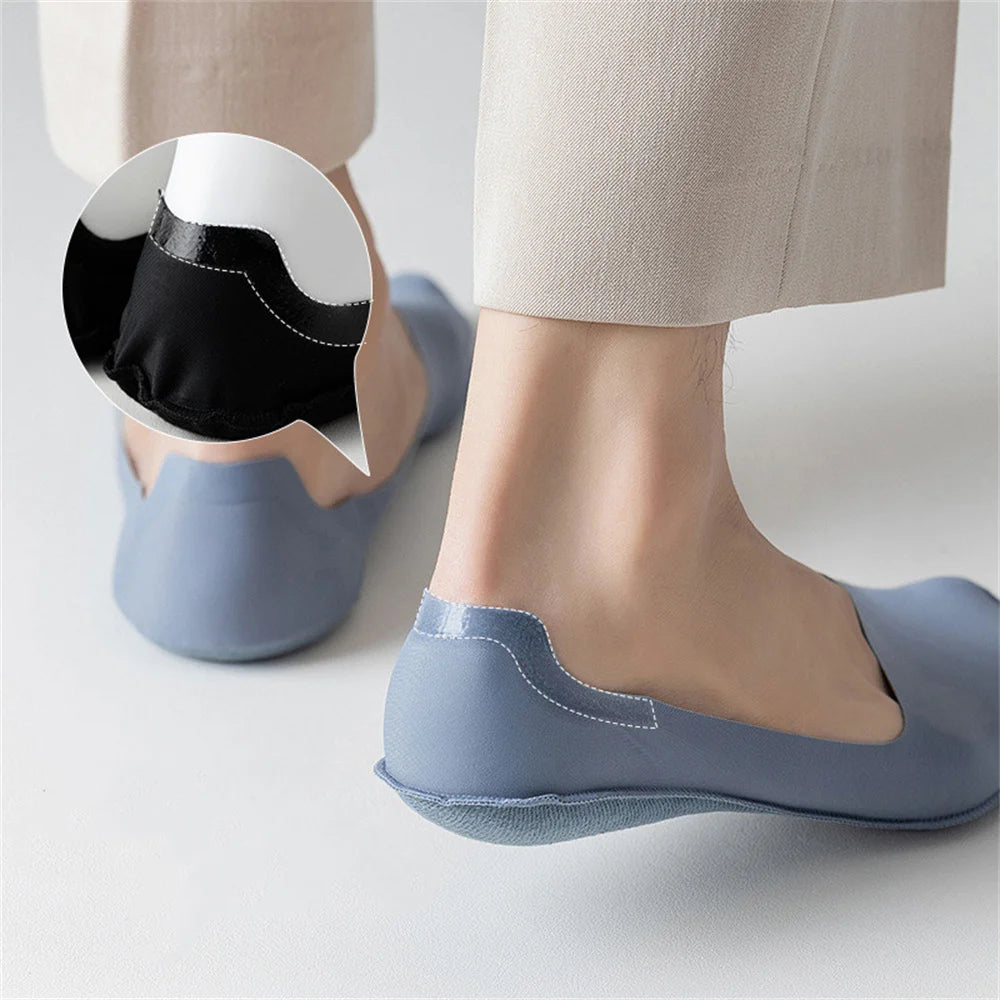 A close-up of a person's foot wearing light blue invisible boat socks with a black heel detail.