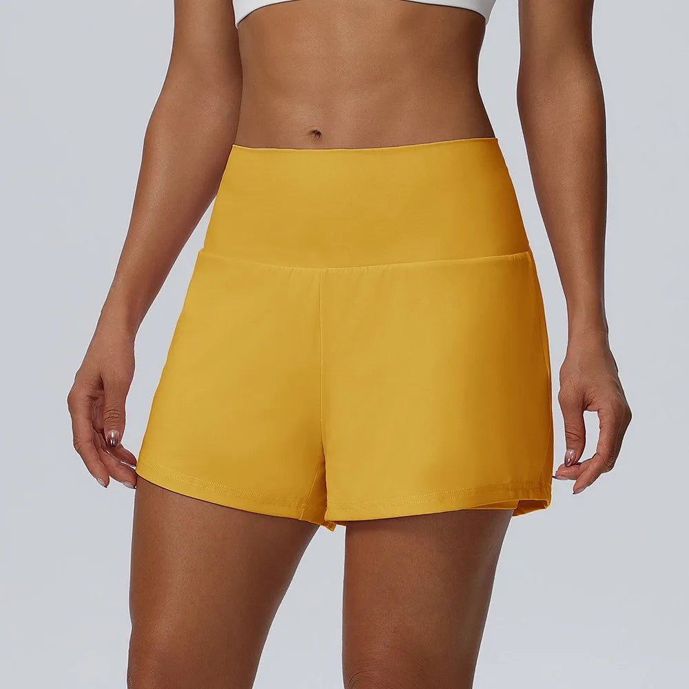 Eine Frau modelliert gelbe sportliche, schnelltrocknende kurze Sporthosen für Damen.