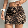 A woman wearing a black and tan leopard print casual mini skirt and a white crop top.