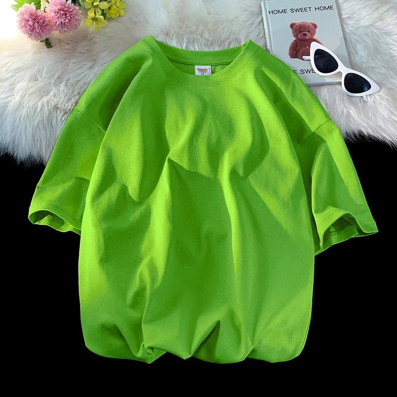 Helles limettengrünes, oversized Baumwoll-T-Shirt einer Frau auf einer weißen flauschigen Oberfläche.