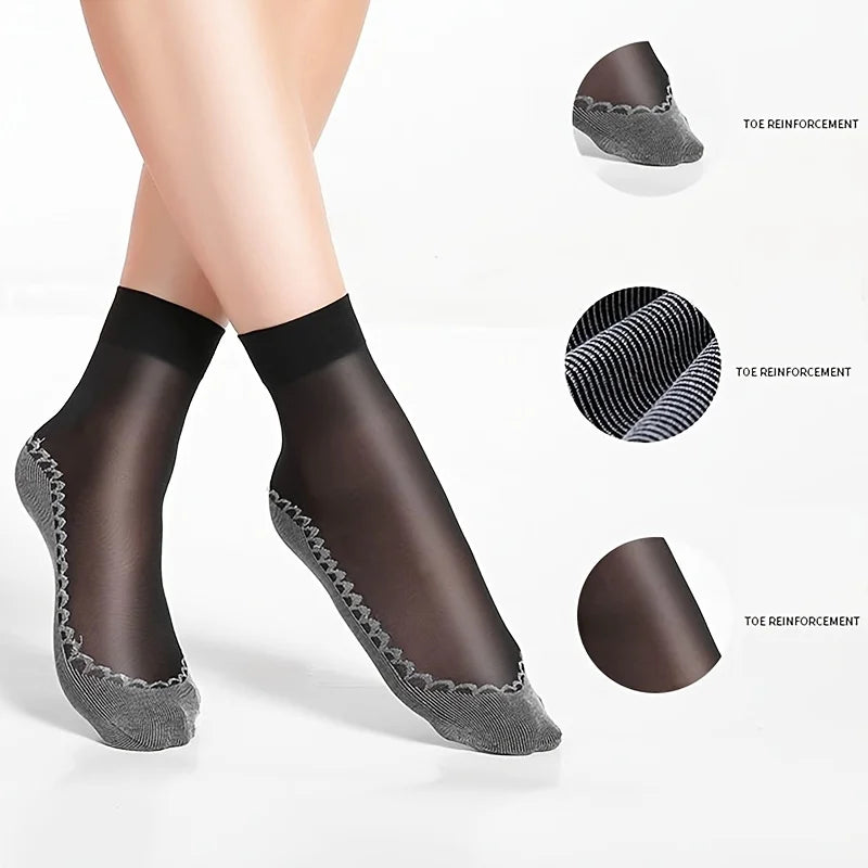 A pair of sheer black ankle socks with textured toe reinforcements shown on a foot.