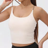 A model wearing a beige women's athletic crisscross tank top and black bottoms.