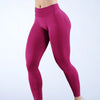 Una modelo lleva unos leggings de yoga sin costuras, de cintura alta y color magenta sólido, en una toma de cuerpo completo.