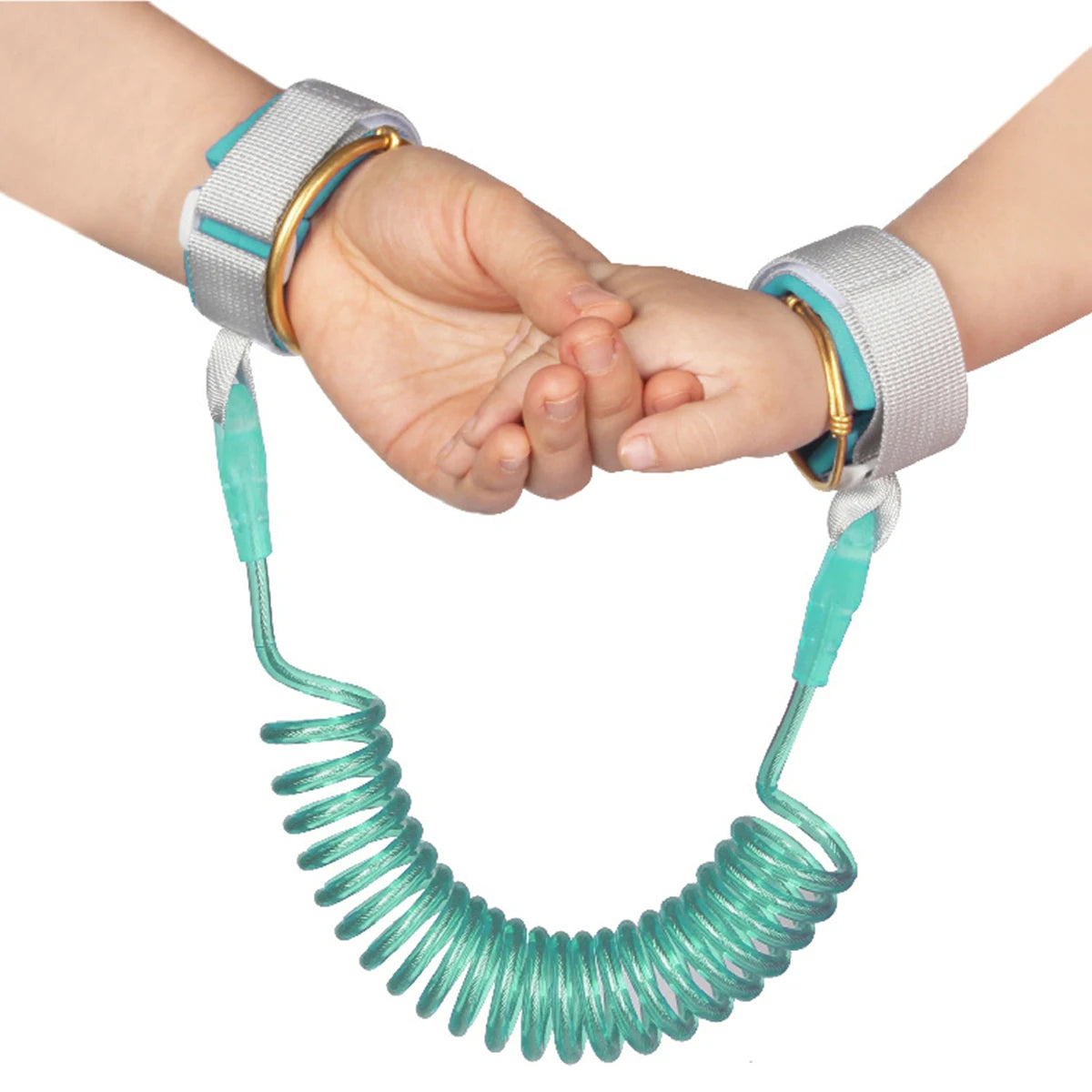 A hand is holding a green, coiled child safety harness and leash.