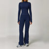A woman wearing a navy blue 3-piece yoga sports set consisting of a long-sleeved top and matching pants.