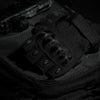 A close-up view of black tactical fingerless gloves resting on a dark fabric background.