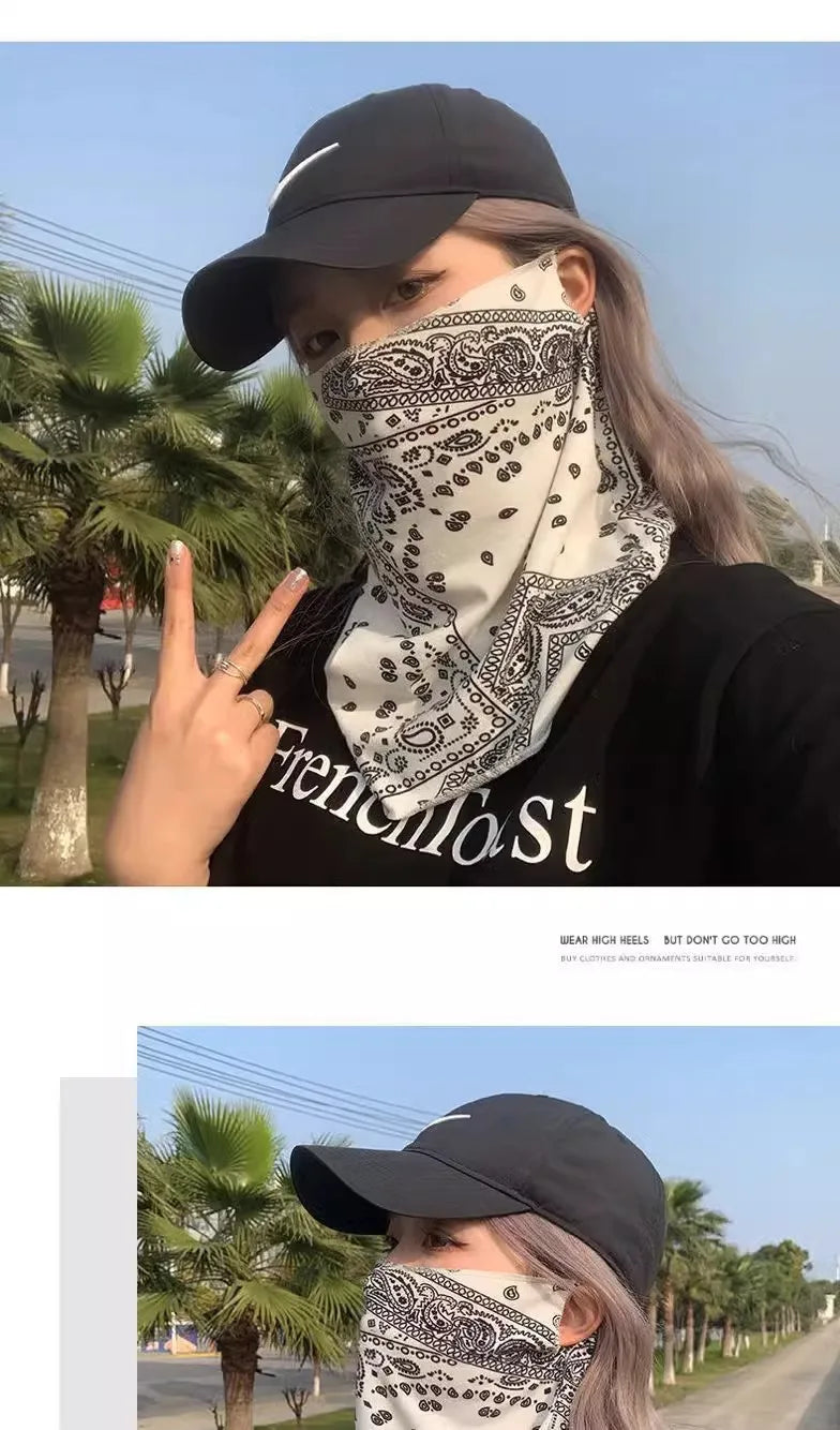 Una mujer vistiendo una gorra de béisbol negra y un pañuelo de cuello blanco con estampado paisley en un entorno al aire libr
