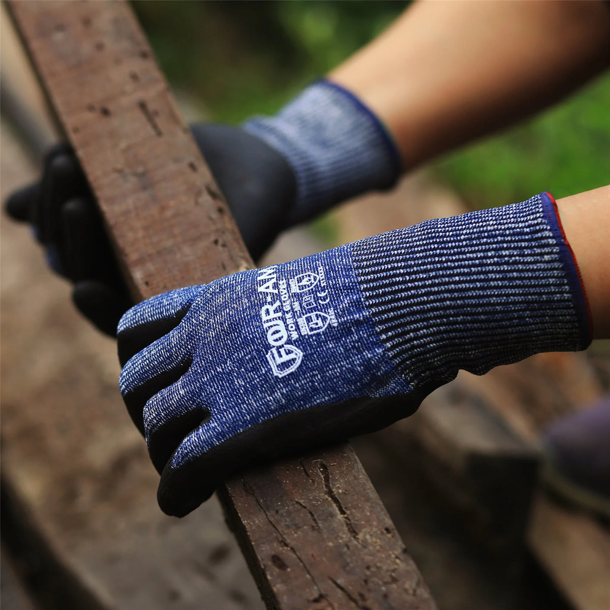 A hand wearing dark blue durable cut-resistant work gloves resting on a wooden surface.
