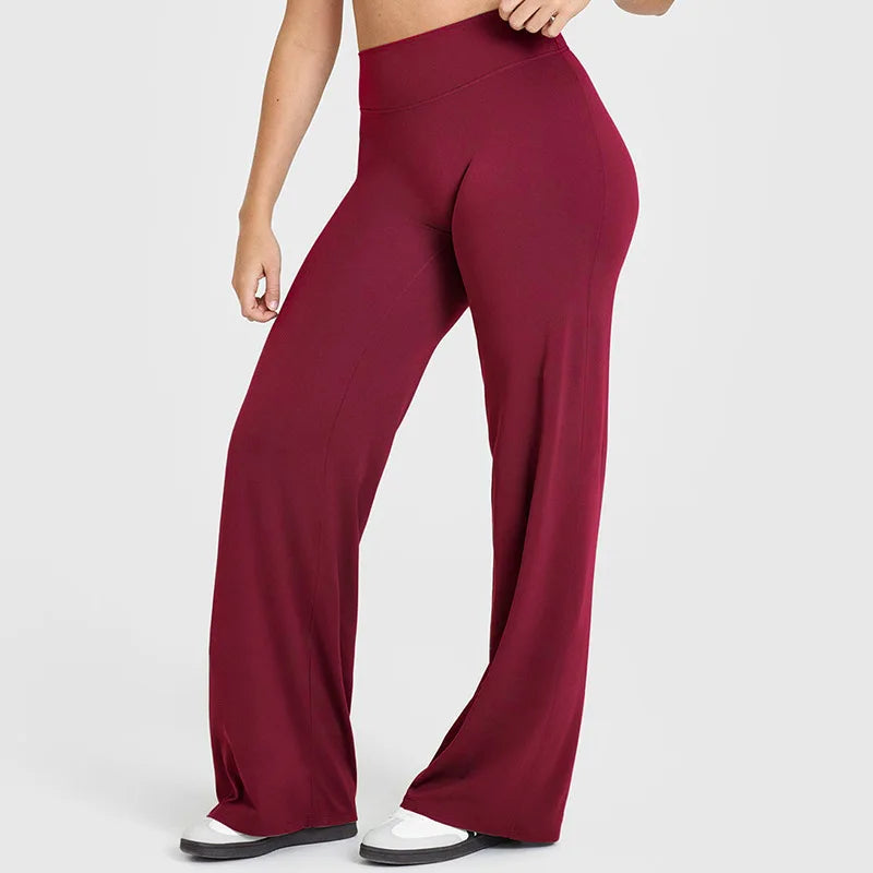 A model wearing maroon high-waist yoga pants in a full-length shot.