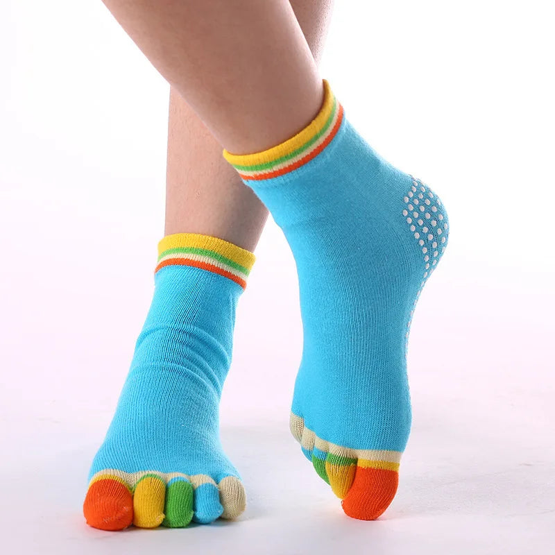 A pair of bright blue rainbow yoga socks with multicolored toe grips