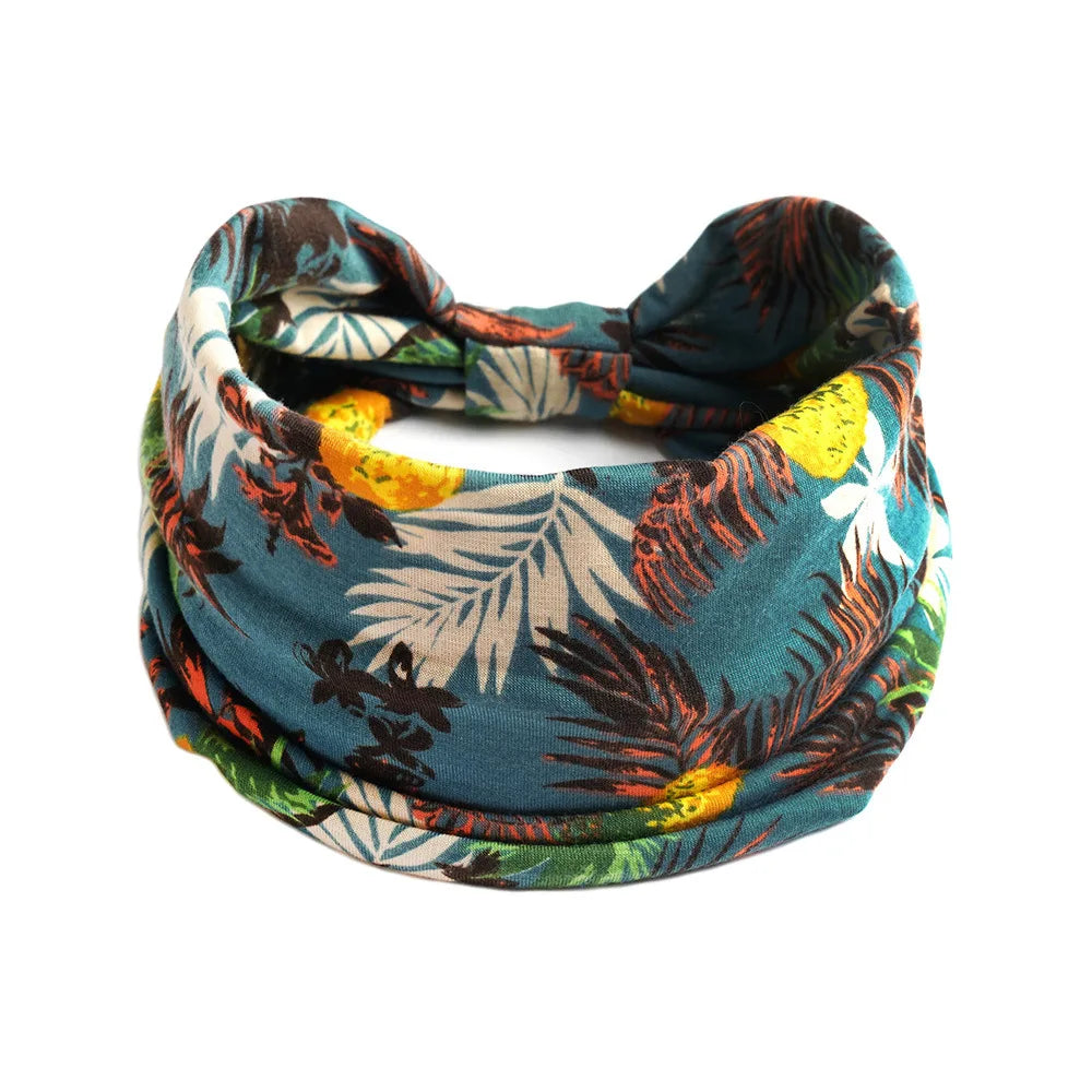 A teal and green bohemian cotton stretch fabric tied into a headband or scarf.