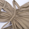A close-up of a beige maxi dress with a draped cut-out back detail.