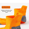 A pair of bright orange and gray performance sports ankle socks displayed for detail.