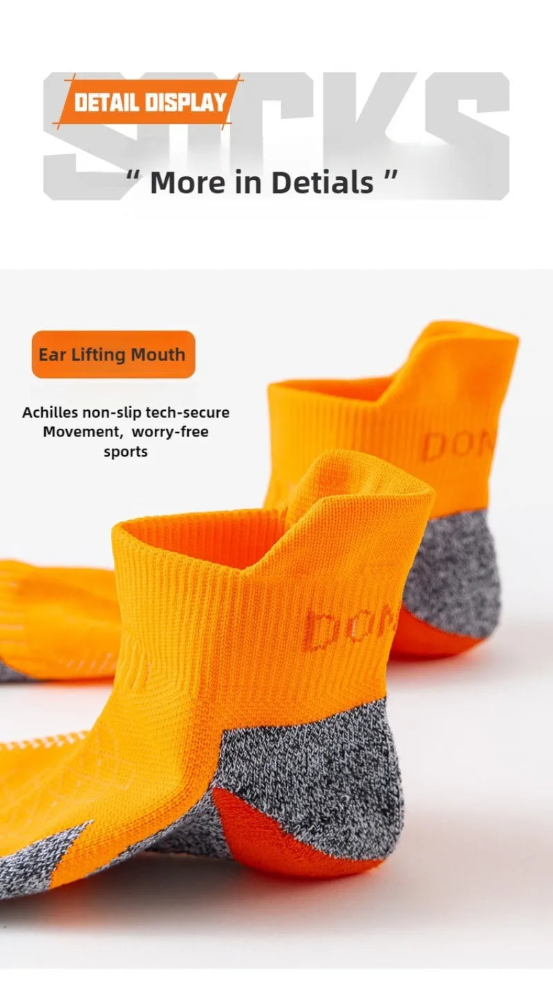 A pair of bright orange and gray performance sports ankle socks displayed for detail.
