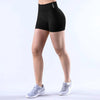 Black seamless high-waisted yoga shorts worn by a model, shown from the side.