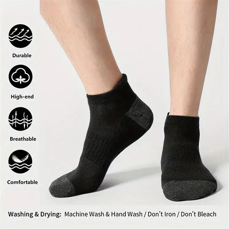A pair of black men's cotton blend ankle socks shown on a person's foot.
