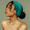 A woman wearing a teal floral knotted cotton headband, looking to the side.