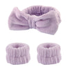 A set of lavender microfiber spa headband and wristband featuring a fluffy texture.