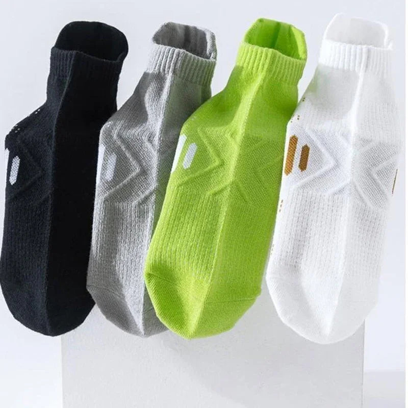 A set of four premium breathable men's running socks in black, gray, lime green, and white.