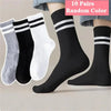 Ten pairs of random color striped casual socks displayed on a person's leg.