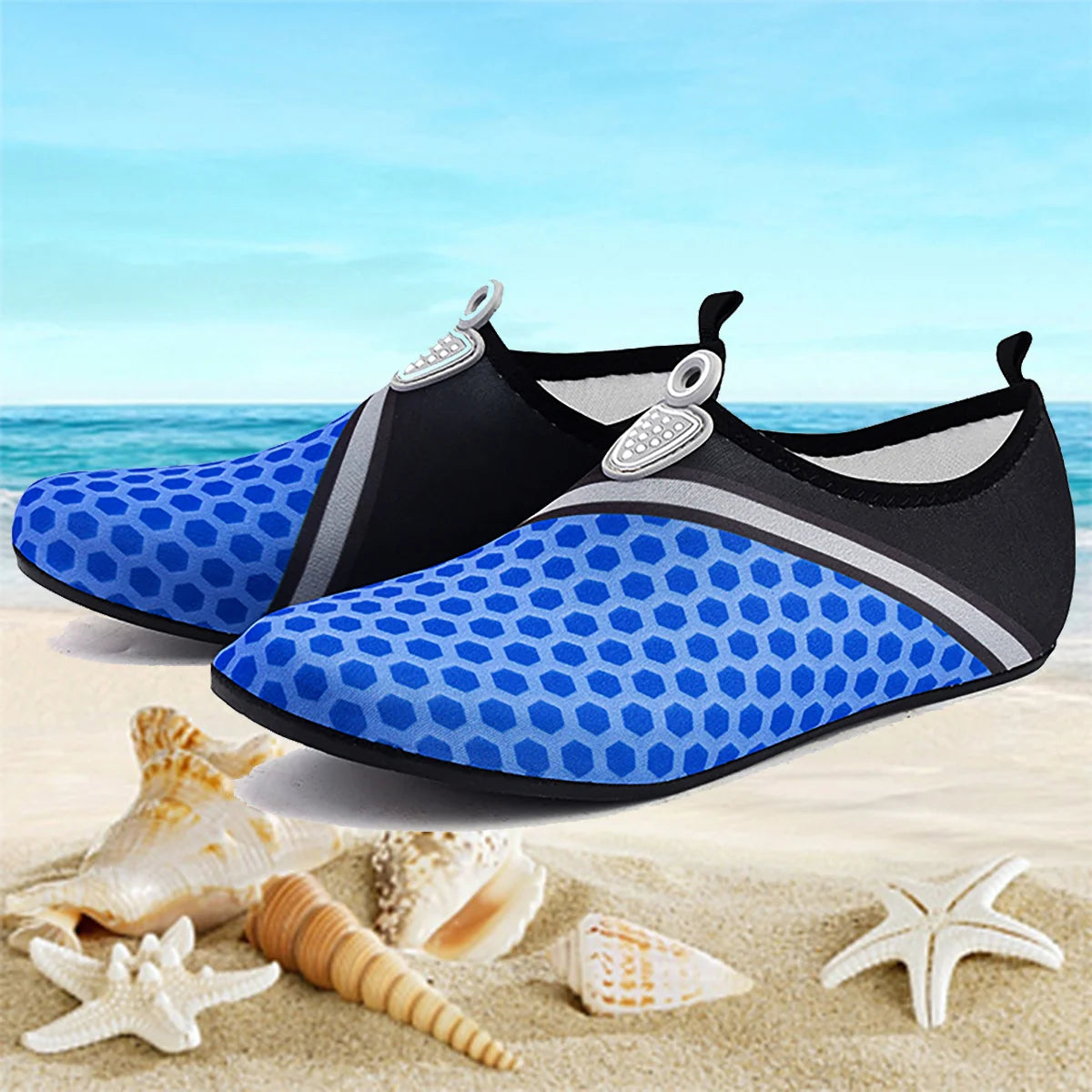 A pair of blue and black waterproof aqua socks resting on sand with seashells.