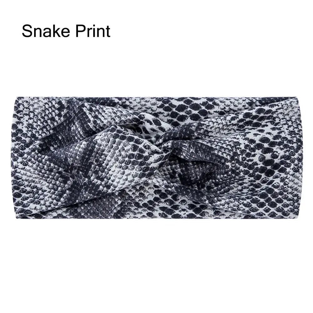 Diadema de tela elástica con estampado de serpiente en blanco y negro.