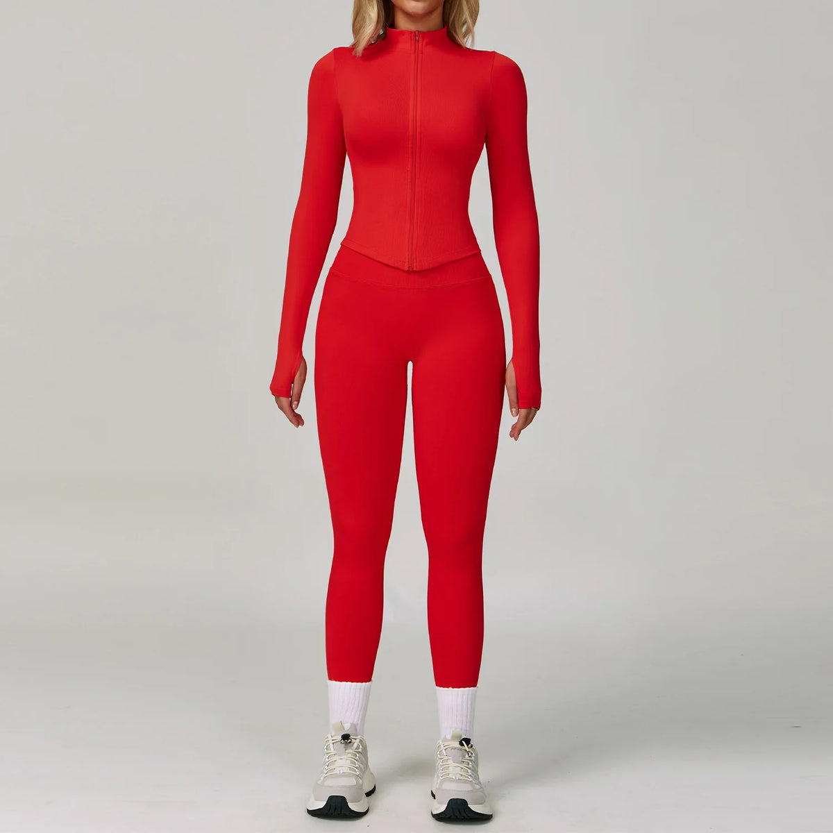 Eine Frau trägt ein langärmeliges, rotes, nahtloses Sport-Yoga-Set mit hohem Kragen und passenden Leggings.
