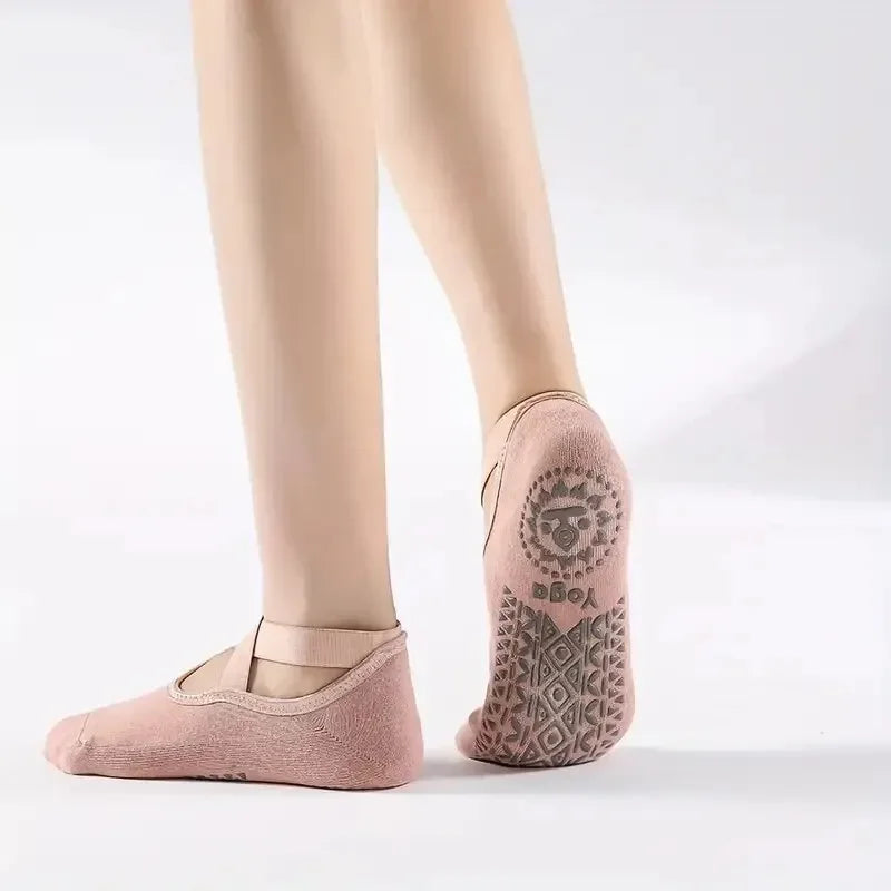 Primer plano del pie de una persona usando calcetines antideslizantes rosas para Pilates y yoga
