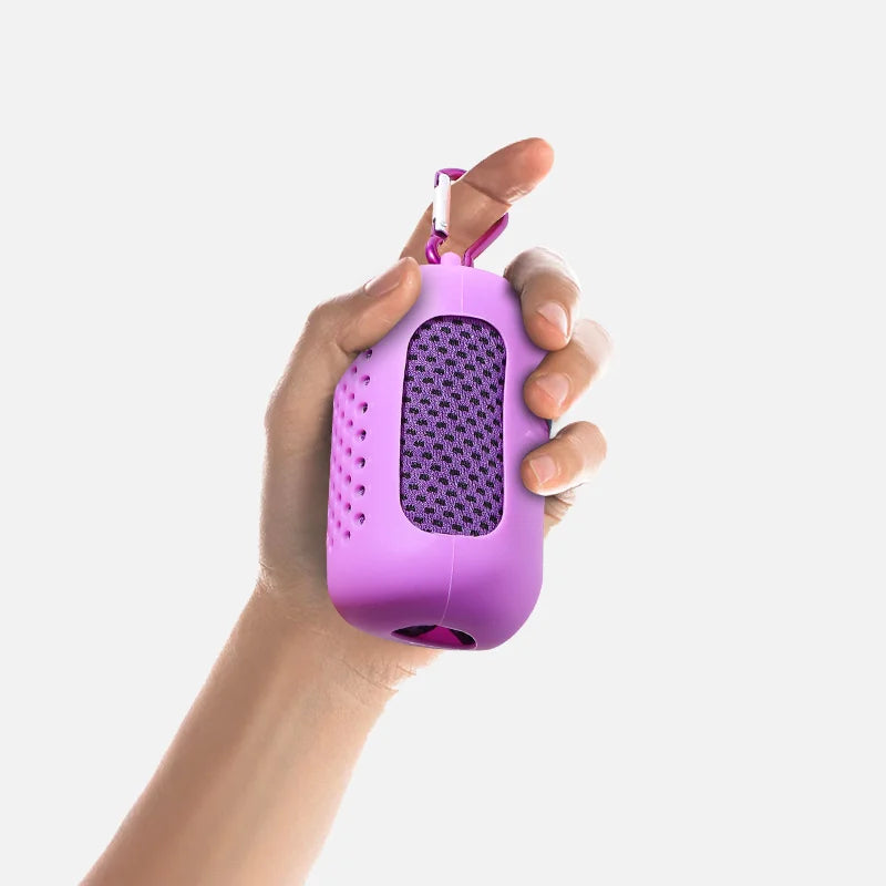 A hand is holding a purple silicone cooling towel with a mesh texture and a strap.