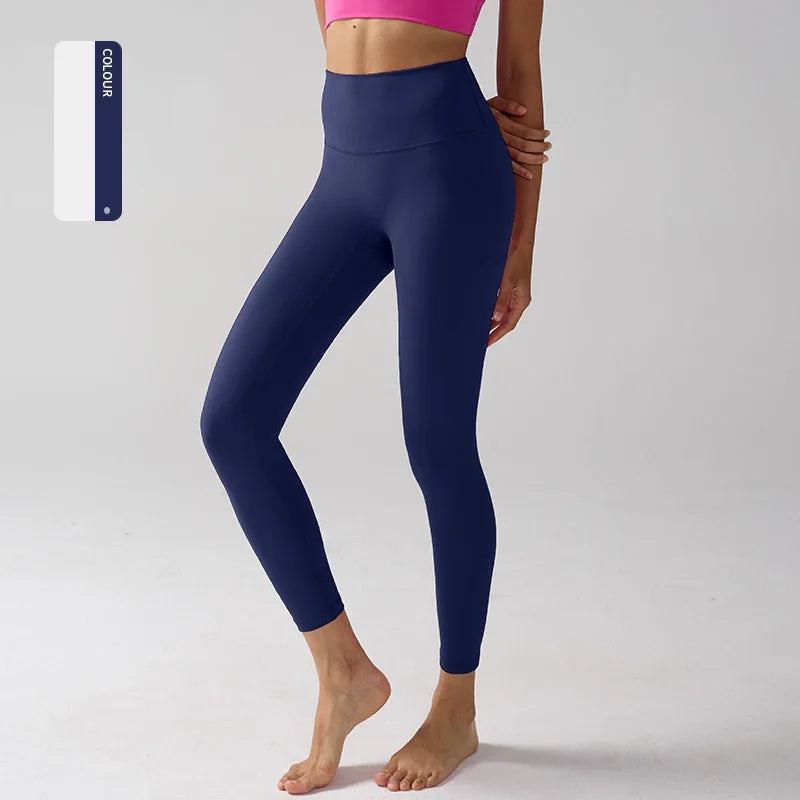 Un mannequin porte un legging de performance bleu marine taille haute et un haut de sport rose.