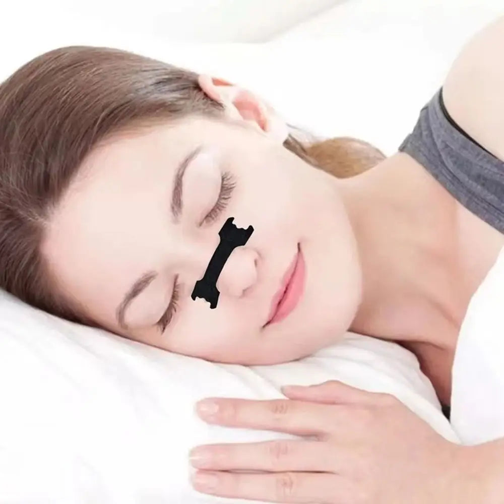 A woman is sleeping with hypoallergenic nasal strips applied to her nose for congestion relief.