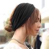 A woman wearing a black adjustable sports headband on her hair, shown in profile.