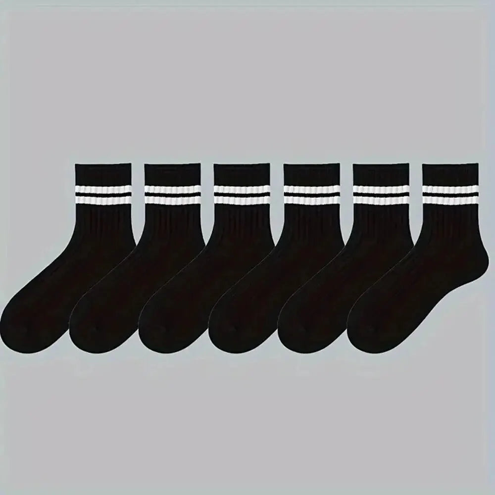 Eine Reihe von schwarzen, gestreiften, atmungsaktiven Herrensocken liegt horizontal.