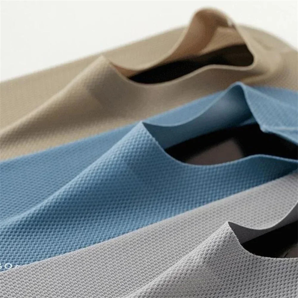 Gros plan de chaussettes en maille bleu clair et gris antidérapantes pliées sur une surface.