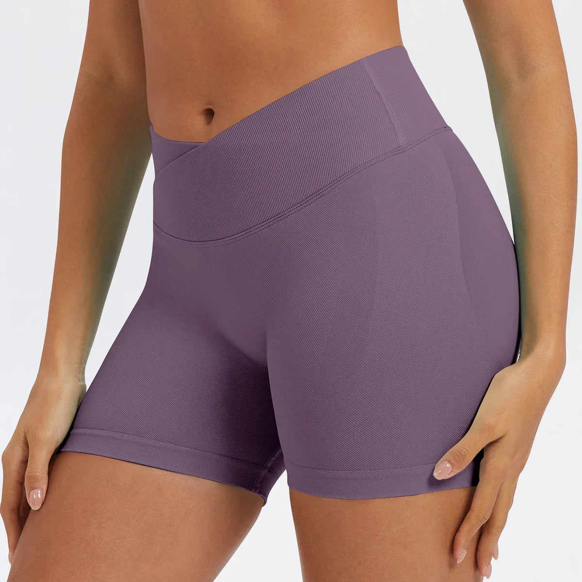 A model wearing seamless high-waist yoga leggings in a mauve purple color.