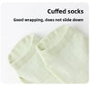 A close-up of a pair of light green cuffed socks shown flat.
