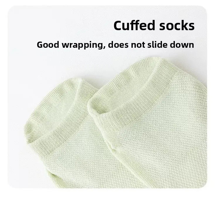 A close-up of a pair of light green cuffed socks shown flat.