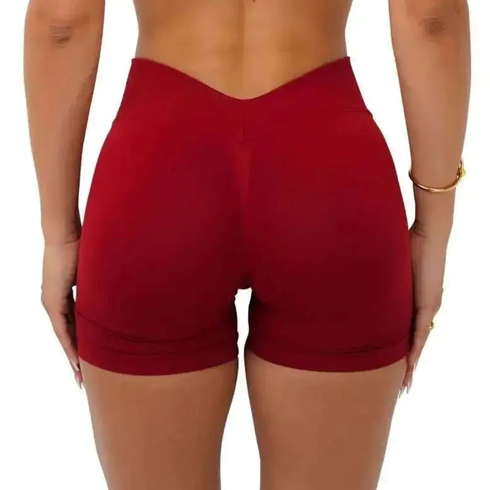 A model is wearing a pair of red seamless yoga shorts for fitness and workout.