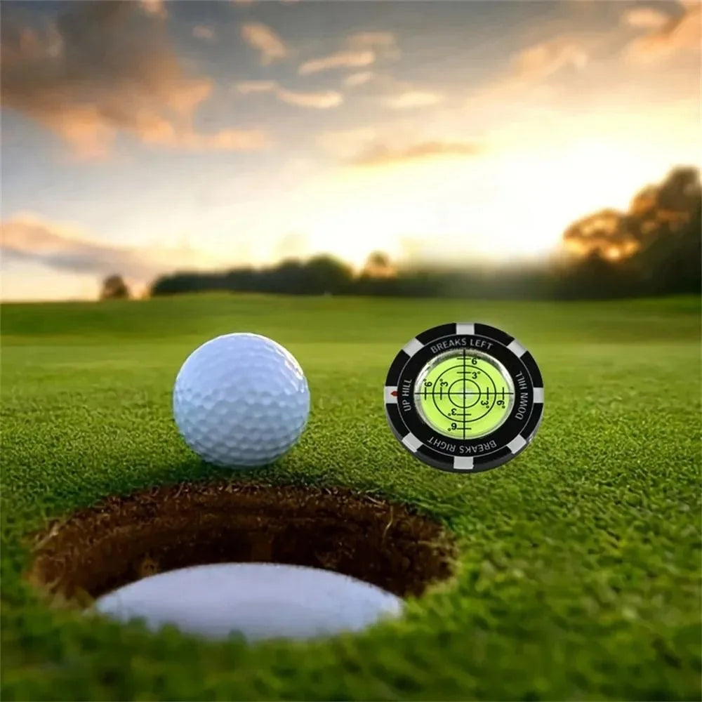 A golf ball rests on a green putting surface next to a depression used as a slope meter.