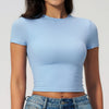 Camiseta de yoga y fitness azul claro de secado rápido usada por una modelo.
