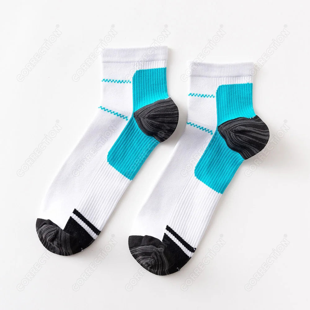 A pair of white compression socks with teal accents and black toe grips.